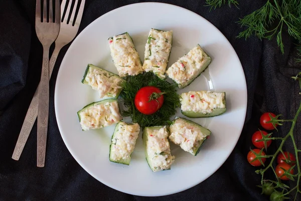 Appetizer from a fresh cucumber with crab meat, egg, cheese and dill. — Stock Photo, Image