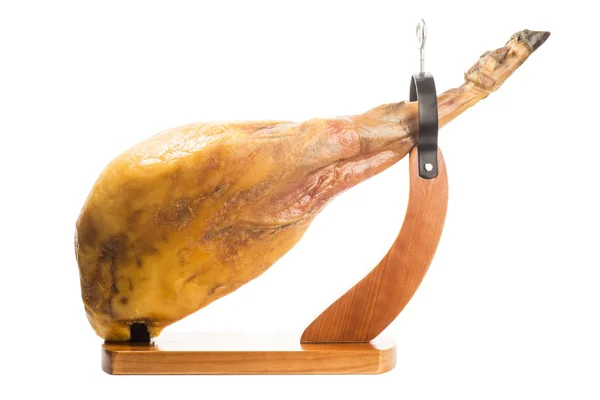 Whole Iberian ham leg in a wooden ham stand isolated — Stock Photo, Image