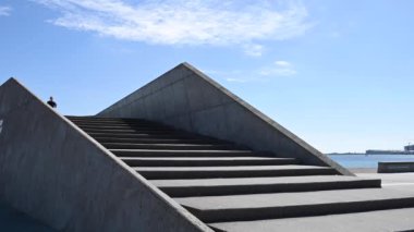 Çekici genç İskandinav, Kafkasyalı kadın, egzersiz yapmak için merdivenlerden iniyor, ağır çekimde. Kamera ona yukarıdan bakıyor. Mavi gökyüzü ve bulutlarla güneşli güzel bir gün. Brian Holm Nielsen 'in stok video görüntüleri