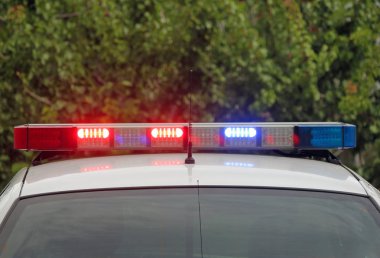 Bir polis arabası üzerinde yanıp sönen ışıklar