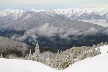 Karla kaplı dağ silsilesi karlı bir alan ötesinde