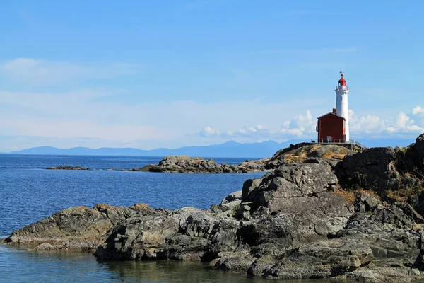 Red and White Lighthouse on a Rocky Coast — Stock Photo, Image
