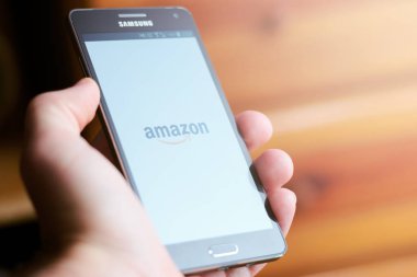 Amazon logo üstünde hareket eden telefon gösterilen el