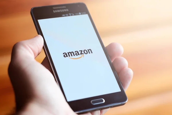 Amazon logo üstünde hareket eden telefon gösterilen el