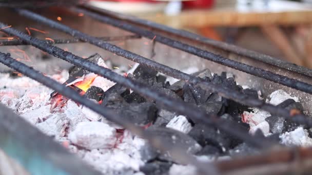 Uitzicht op een gloeiende houtskool en de vlam in de barbecue grill sluit. Brandende vuur en heldere kolen. Ondiepe scherptediepte. Tropische eiland Bali, Indonesië. — Stockvideo
