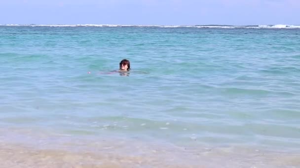 Brunette young sexy attractive woman swimming in the ocean on Bali island, Indonesia. Slow motion, full hd, 50 fps. Fit female living healthy wellness lifestyle on the beach. — Stock Video