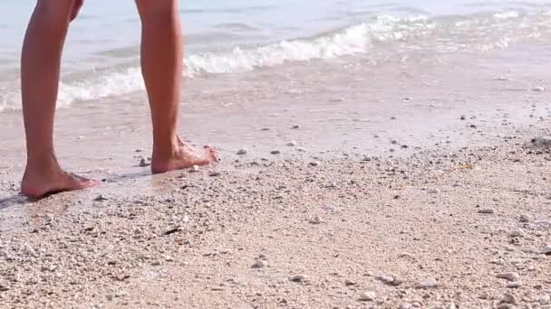 Junge Frau sexy nackte Beine, die auf der tropischen Meeresküste in Zeitlupe laufen. Strand von Bali, Indonesien. Wellen mit Ozean auf einem Hintergrund. Mädchen läuft barfuß am nassen Sandstrand neben tropischem Ozean. — Stockvideo