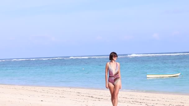 Σέξι ελκυστική νεαρή καυκάσιος γυναίκα σε μια όμορφη τροπική παραλία, περπατώντας στην παραλία του Μπαλί, Ινδονησία. Τατουάζ στην πλάτη της. Απολαμβάνοντας τη φύση και τον τρόπο ζωής στις διακοπές. Ωκεανός στο παρασκήνιο. — Αρχείο Βίντεο