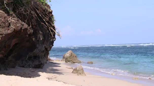 Rock az óceánon, hogy elütötte a hullámok egy gyönyörű összetételét. Bali, Indonézia. — Stock videók