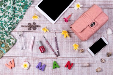 Egzotik moda pembe yılan derisi çantalar ahşap arka plan, üstten görünüm, metin, smartphone ve tablet ile siyah ekran için boş alan. Moda kadınlar tropik çiçekler plumeria ile ayarlayın. Kelime 