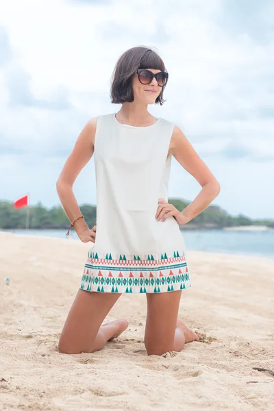 Retrato de beleza de mulher morena sexy em vestido branco na praia com óculos de sol. Cruzeiro moda verão. Bali, Indonésia. Vista mar . — Fotografia de Stock