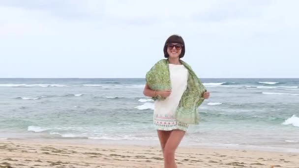 Running vrouw buitenshuis strand. Mooie jongedame met glazen en groene zijden sjaal, Bali, Indonesië. — Stockvideo