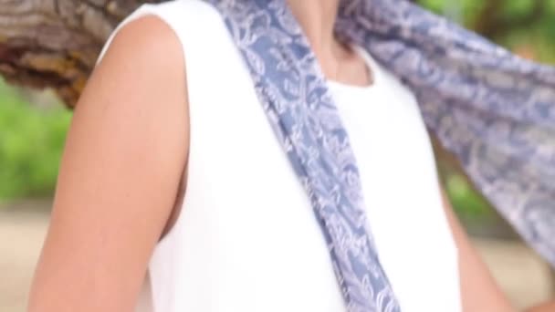 Happy young woman in white dress with sunglasses and balinese silk scarf whirling at the beach. Slow motion. Bali, Indonesia. — Stock Video