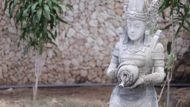 Asiatische balinesische Sandsteinskulptur einer Frau mit Krug. Zeitlupe. tropische Insel Limbongan, Indonesien. Hindu-Statue. — Stockvideo
