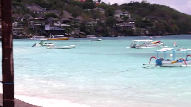 Piccole barche al rallentatore nell'oceano blu. Vista mozzafiato, acqua cristallina, posto tranquillo per riposarsi. Isola tropicale di Lembongan, Indonesia. Paradiso . — Video Stock