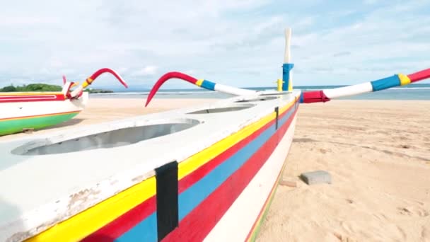 Barco de pesca colorido de madeira na praia com céu azul. Nusa Dua, Bali, Indonésia. Movimento lento . — Vídeo de Stock