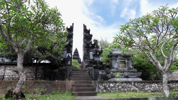 Balinesiska tempel på solig dag, Bali, Indonesien. Vackra moln. Plumeria träd på ingången. — Stockvideo