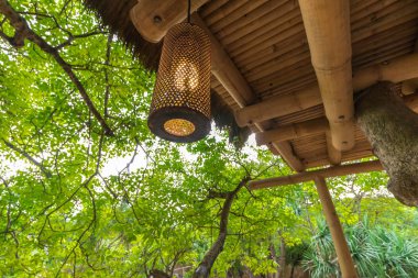 Ahşap çardak dışında güzel yeşil arka plan içinde yakalandı asılı lamba dekore edilmiştir. Tropikal Bali Adası, Endonezya.