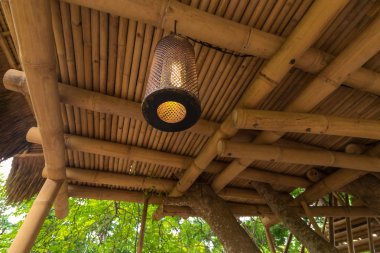 Ahşap çardak dışında güzel yeşil arka plan içinde yakalandı asılı lamba dekore edilmiştir. Tropikal Bali Adası, Endonezya.