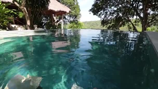 Couple man feet in swimming pool. Tropical island Nusa Lembongan, Indonesia. The pool on the cliff. — Stock Video