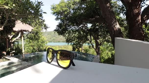 Sonnenbrille am Pool. tropische insel nusa limbongan, indonesien, asien, resort. — Stockvideo