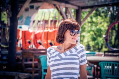 Oturma ve tropik ada sahilde Nusa Lembongan, Endonezya poz güzel sağlıklı genç bir beyaz kadın portresi. Asya, yaz güneşli gün.