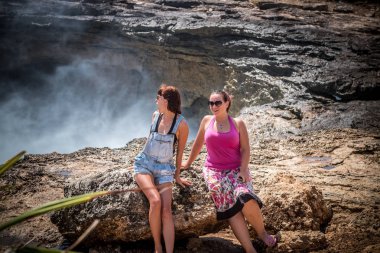 İki genç ve seksi kadın vahşi Okyanusu yakınlarındaki buzlu. Fırtına geliyor ve sıçramasına büyük dalgalar. Tropik ada Nusa Lembongan, Endonezya, Asya. Devils gözyaşı yer adıdır.