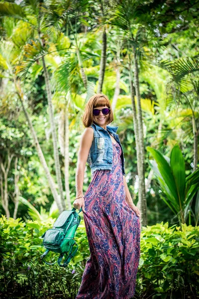 Elegante dama con un elegante peinado corto y gafas con una mochila de piel de serpiente de pitón de lujo. La isla de Bali. Asia, Indonesia . — Foto de Stock