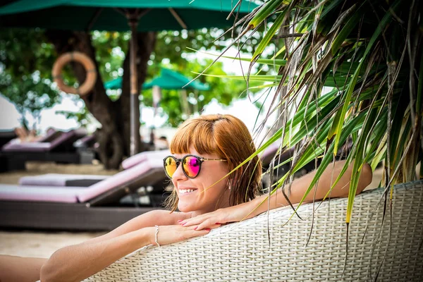 Ontspannen op de ligstoel. Mooie jonge vrouwen in zonnebril ontspannen op de ligstoel op het strand. Sexy vrouw portret. — Stockfoto