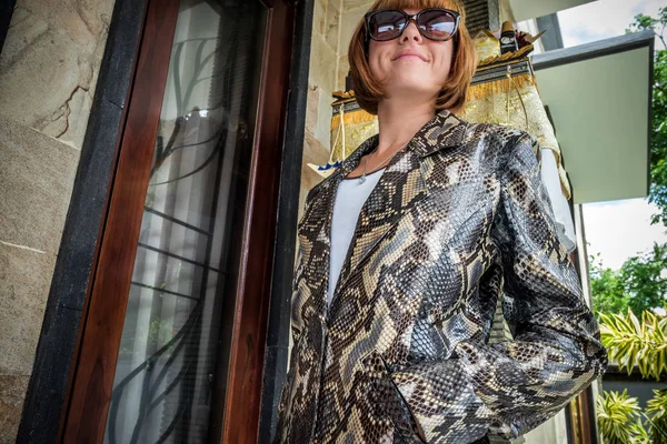 Young woman, luxury fashion snakeskin python cape cloak. Handmade snakeskin coat.