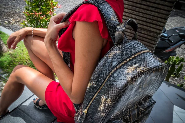 时尚女郎穿着红色带皮革蛇皮 python 背囊亚洲花园里。热带巴厘岛，手工蛇皮豪华背包. — 图库照片