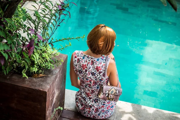 Portret van de zomer van een mooie sexy meisje met zonnebril en luxe handgemaakte slangenhuid python handtas in het zwembad. Mode buiten. Tropische eiland Bali, Indonesië. — Stockfoto