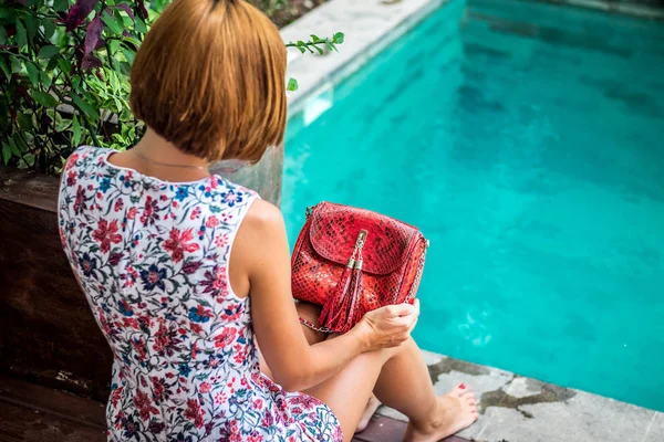 Ritratto estivo di una bella ragazza sexy con occhiali da sole e lussuosa borsa in pitone di pelle di serpente fatta a mano in piscina. Moda outdoor. Isola tropicale di Bali, Indonesia . — Foto Stock