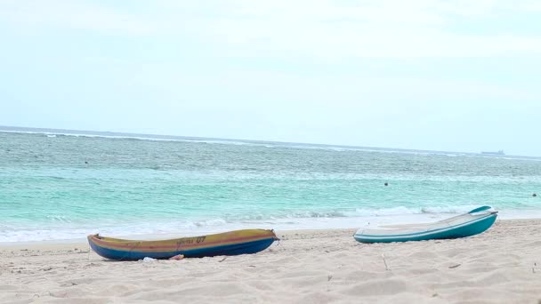 Eenzame kajak-kano op het strand van het tropische eiland Bali, Indonesië. Blauwe oceaan op een achtergrond. — Stockvideo