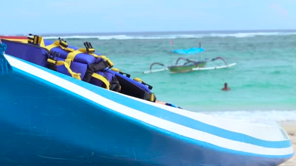 Lonely kayak canoe on the beach of tropical island Bali, Indonesia. Blue ocean on a background. — Stock Video