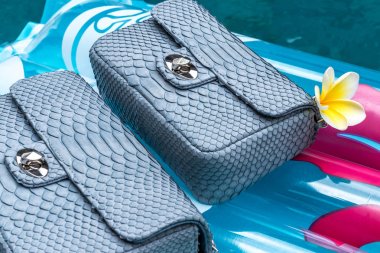 Kadın lüks yılan derisi python çanta yüzme havuzunda. El yapımı lüks çanta.