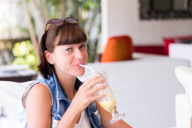 Cafe içme içinde güzel genç kadın kokteyl portresi. Lezzetli güneşli günde kokteyl serinletici. Meyve içecekler. Taze meyve suyu. Kadın bir yaz günü, Bali rahatlatıcı.