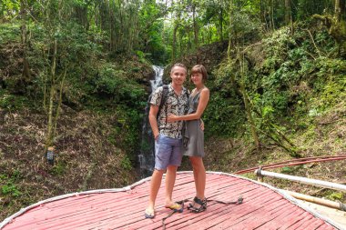 Sevgi genç balayı çift birlikte yağmur ormanlarında ayakta in atış. Yakınındaki bir şelale, tropikal Bali Adası, Endonezya ormanda ayakta aşık Çift.