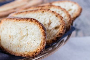 Rustik ahşap masa üzerine dilimlenmiş ekmek fırından yeni çıkmış, kahverengi ekmek yakın çekim.