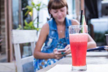 Taze karpuz suyu ile nane, limonata. Vitaminler, yaz için sağlıklı içecek vejetaryen için uygun. Arka plan bulanık Smartphone'da olan genç kadın.