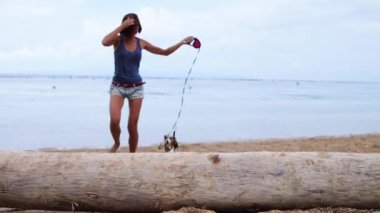 Ada Bali, Sanur, Endonezya kadın ve tropikal plajda oynayan sevimli Beagle köpek.