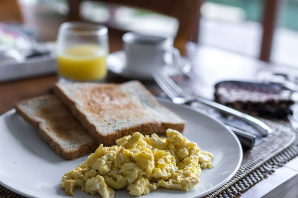 Тост с яичницей, на белой тарелке в роскошной тропической вилле. Вкусный завтрак с кофе и апельсиновым соком. На светлом фоне, вид сверху. Бали, Индонезия . — стоковое фото