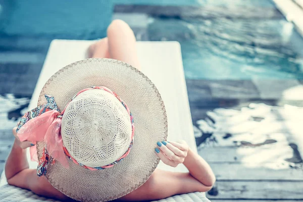 Schoonheid sexy vrouw met hoed en zonnebril haar zomervakantie genieten bij zwembad op een luxevilla. De zomervakantie is idyllisch. Tropische eiland Bali, Indonesië. — Stockfoto