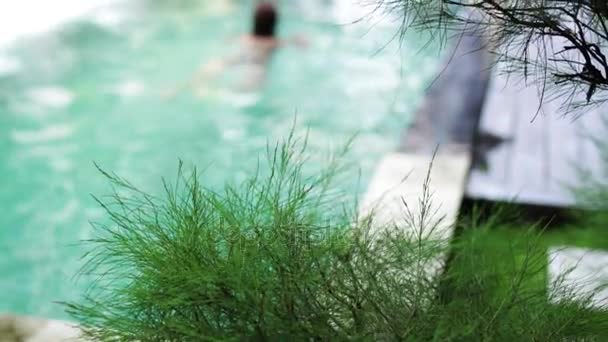 Atractiva joven mujer caucásica disfrutando del tiempo libre en su piscina en una villa de lujo, isla tropical Bali, Indonesia. Movimiento lento . — Vídeos de Stock