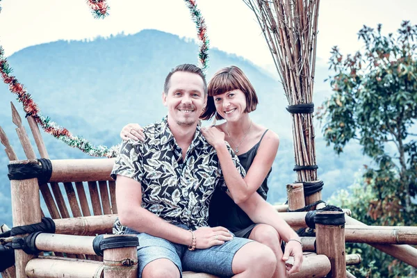 Una romantica coppia luna di miele sulla sedia di legno sulle montagne dell'isola tropicale di Bali, Indonesia . — Foto Stock