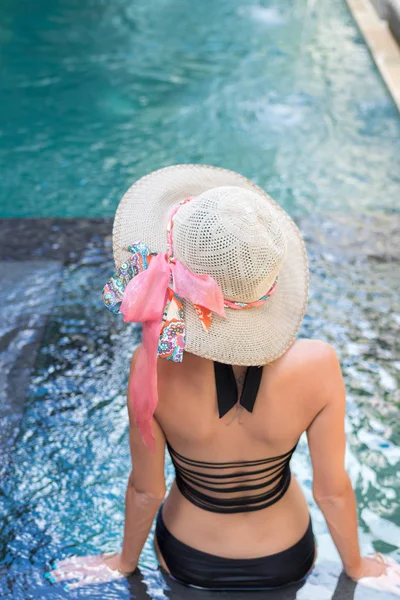Jonge vrouw in zwembroek in zwembad in prachtige resort, luxevilla, tropische eiland Bali, Indonesië. — Stockfoto