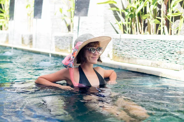 Ung kvinna i baddräkt i poolen i underbara resort, lyxvilla, tropiska ön Bali, Indonesien. — Stockfoto