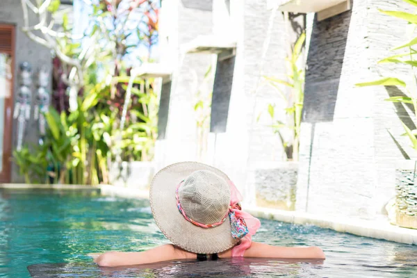 Jonge vrouw in zwembroek in zwembad in prachtige resort, luxevilla, tropische eiland Bali, Indonesië. — Stockfoto