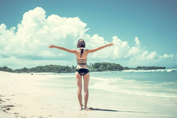 Concept van de vrijheid. Vrijheid en geluk vrouw op het tropische strand van Bali eiland, Indonesië. Ze is genieten van serene Oceaan natuur tijdens reizen vakantie vakantie buitenshuis. — Stockfoto