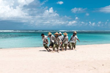 Bali, Endonezya - 26 Nisan 2017: büyük bir ağaç Endonezya Bali Adası'getirdiğin Paradise beach işçi.